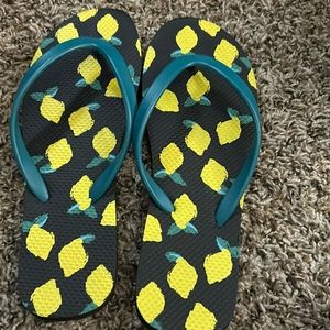 Cute summer time flip flops with lemons on them.
